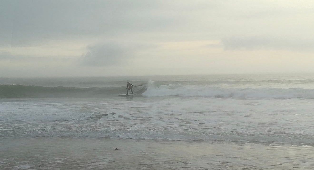 Surfeur dans la lumière du matin