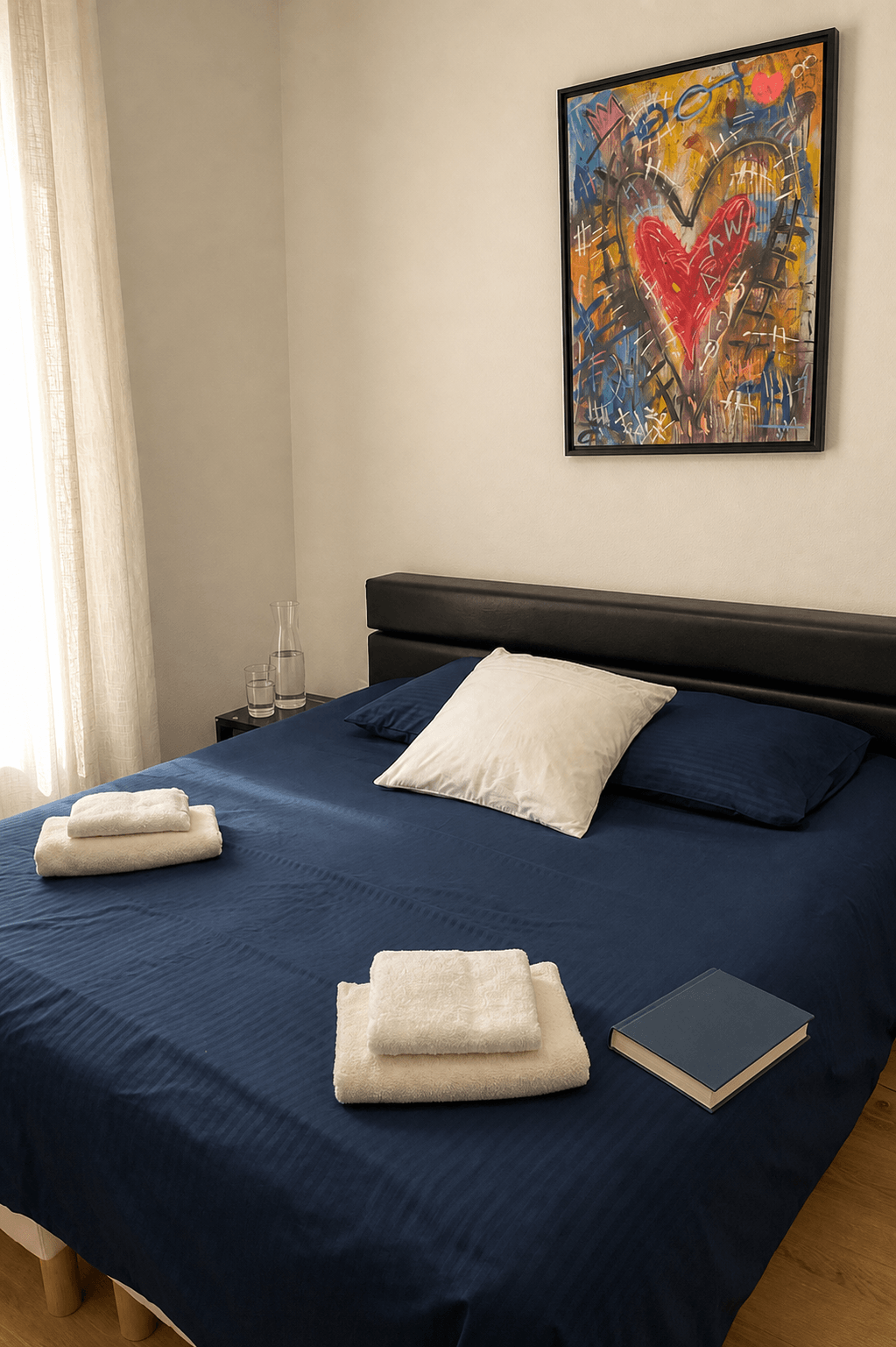 Chambre du Nid d’Été préparée avec livre, eau et linge