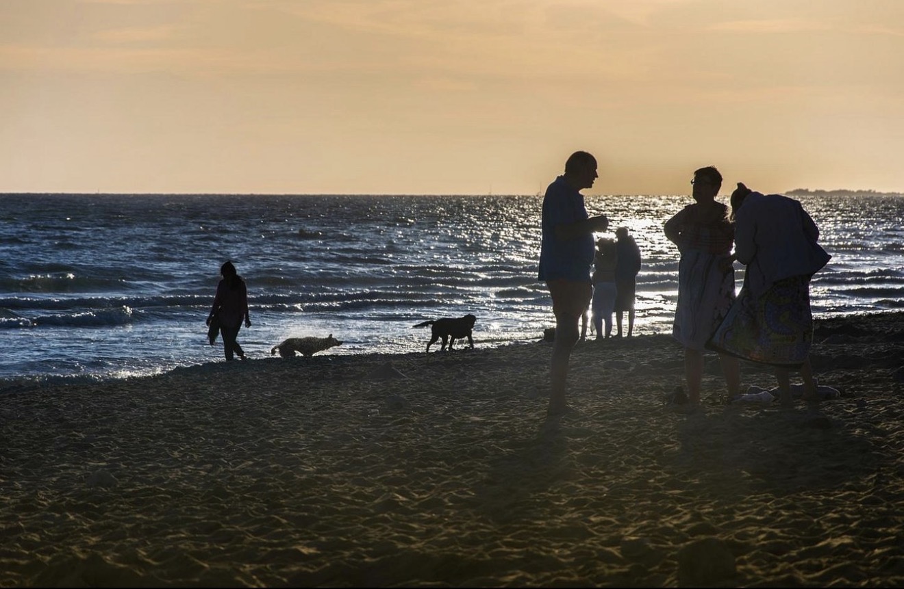 Moment partagé en famille au coucher du soleil sur l’océan