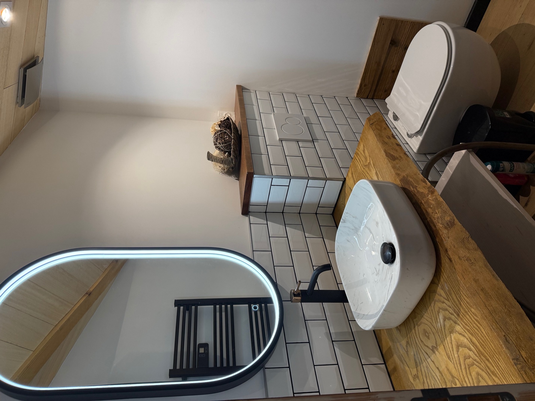 Vasque contemporaine, miroir éclairé et toilettes dans la salle d’eau du Chai