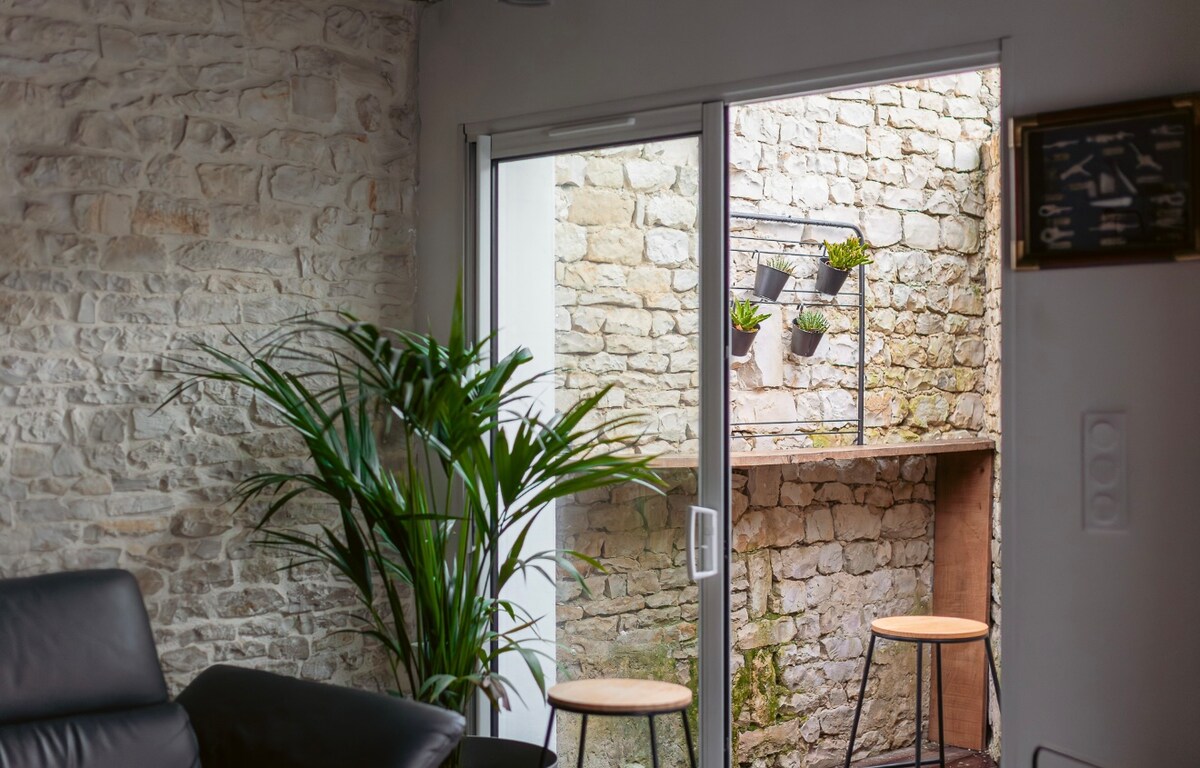 Une fenêtre du Chai ouverte sur le mur en pierre