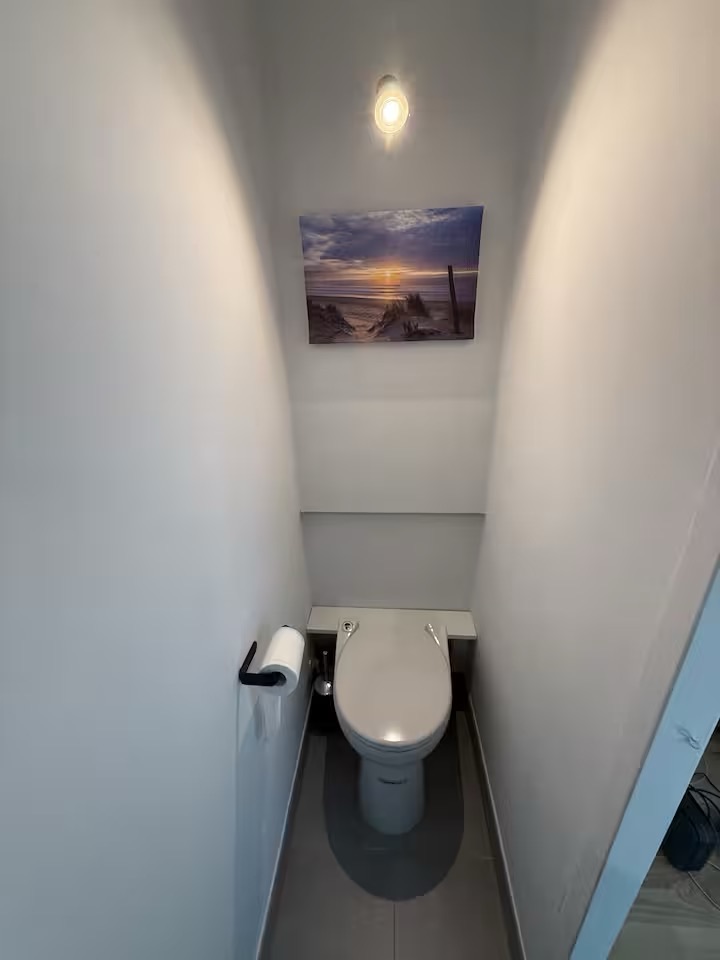 Toilettes indépendantes décorées d’une photographie de l’océan